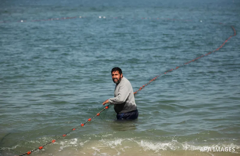 Palestinian fishermen pull their net at the beach in Gaza City on April 03, 2016. Israel on Sunday extended the distance it permits Gaza fishermen to head out to sea along certain parts of the coastline of the enclave, w...