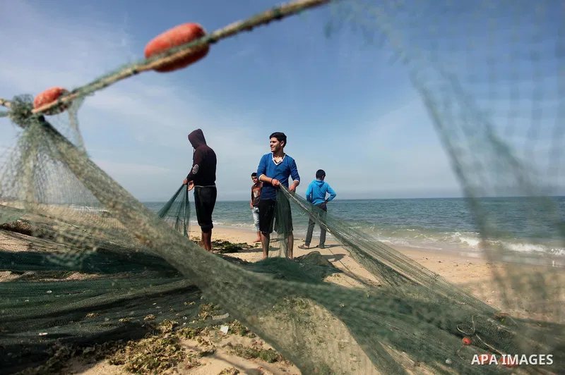Palestinian fishermen pull their net at the beach in Gaza City on April 03, 2016. Israel on Sunday extended the distance it permits Gaza fishermen to head out to sea along certain parts of the coastline of the enclave, w...