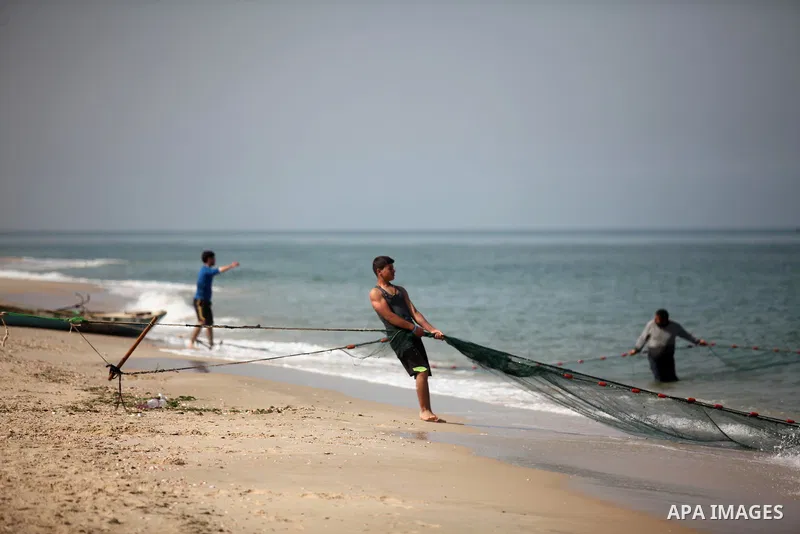 Palestinian fishermen pull their net at the beach in Gaza City on April 03, 2016. Israel on Sunday extended the distance it permits Gaza fishermen to head out to sea along certain parts of the coastline of the enclave, w...