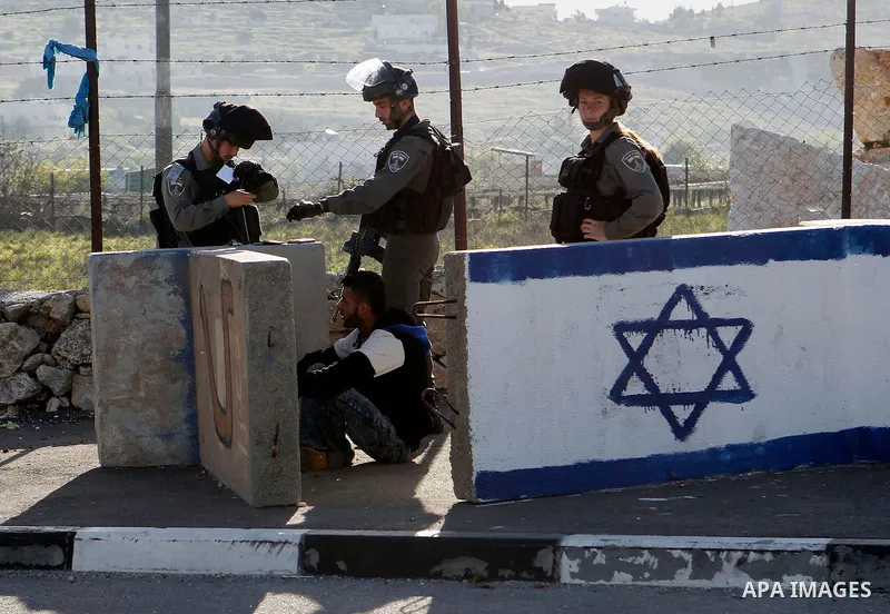 Israeli border policemen arrest a Palestinian man at the Beit Ainun junction near the West Bank city of Hebron, on April 4, 2016. The man reportedly was arrested within the usual security measures taken in the region by...
