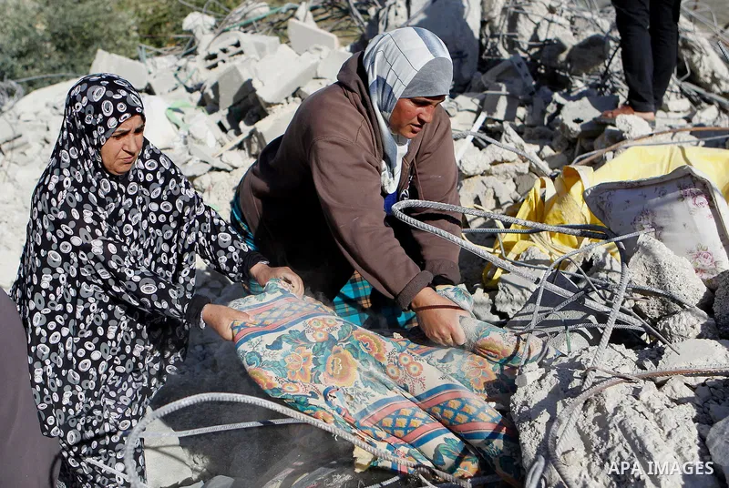 Palestinians collect belongings near the rubble of their house that were demolished by the Israeli army, after Israeli authorities said it was built without a permit, in the village of Sourif the west bank city of Hebron...