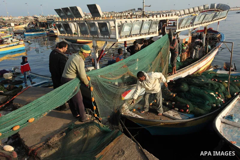 Palestinian fishermen pull their net at the beach in Gaza City, on April 4, 2016. Israel on Sunday extended the distance it permits Gaza fishermen to head out to sea along certain parts of the coastline of the enclave, w...