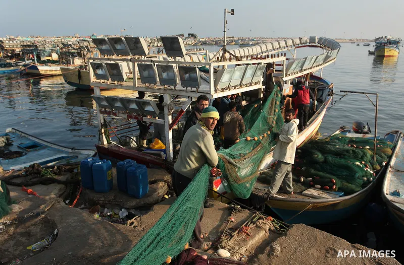 Palestinian fishermen pull their net at the beach in Gaza City, on April 4, 2016. Israel on Sunday extended the distance it permits Gaza fishermen to head out to sea along certain parts of the coastline of the enclave, w...