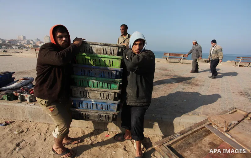 Palestinian fishermen display fish for sale, in Gaza seaport, on April 4, 2016. Israel on Sunday extended the distance it permits Gaza fishermen to head out to sea along certain parts of the coastline of the enclave, whi...