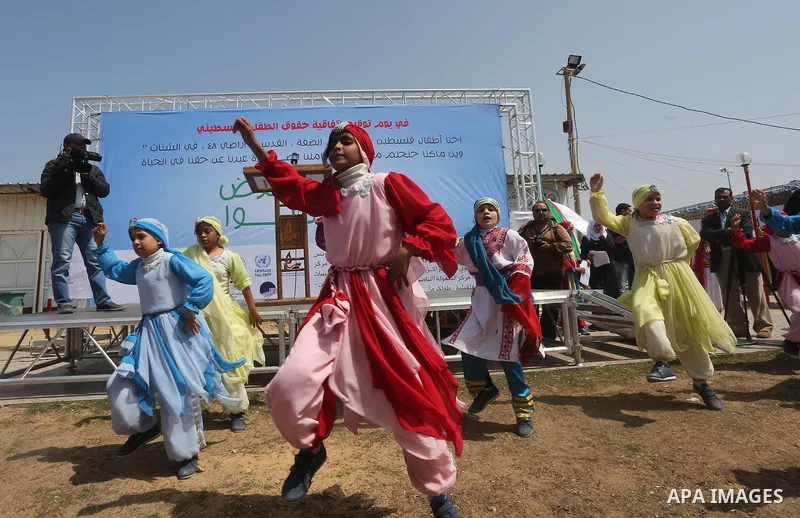 Palestinian children take part in a ceremony to mark Palestinian child day in Gaza seaport, on April 6, 2016. Photo by Mohammed Asad