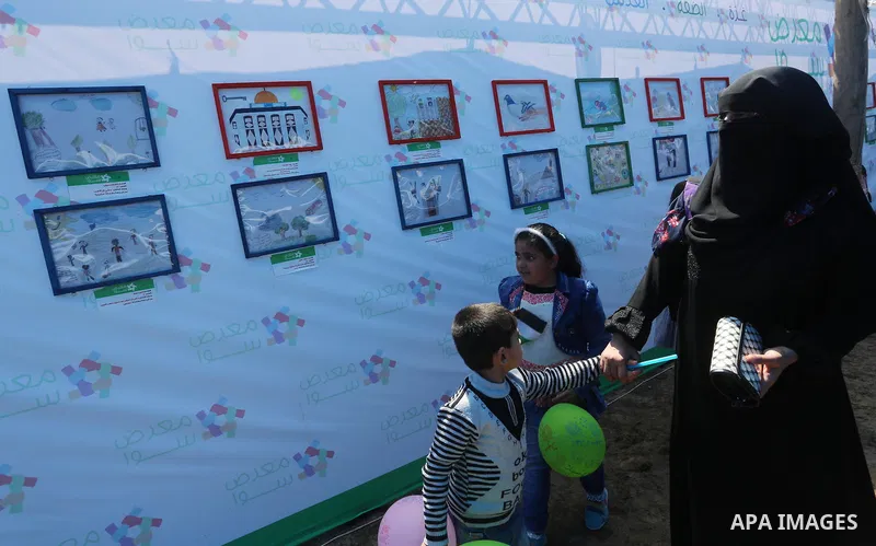 Palestinians attend a photo gallery to mark Palestinian child day in Gaza seaport, on April 6, 2016. Photo by Mohammed Asad