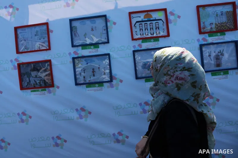 Palestinians attend a photo gallery to mark Palestinian child day in Gaza seaport, on April 6, 2016. Photo by Mohammed Asad