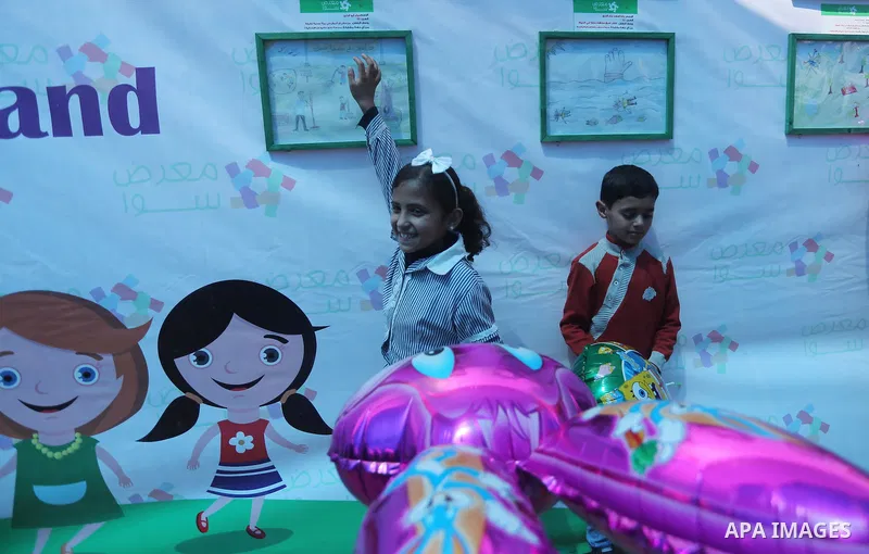 Palestinians attend a photo gallery to mark Palestinian child day in Gaza seaport, on April 6, 2016. Photo by Mohammed Asad