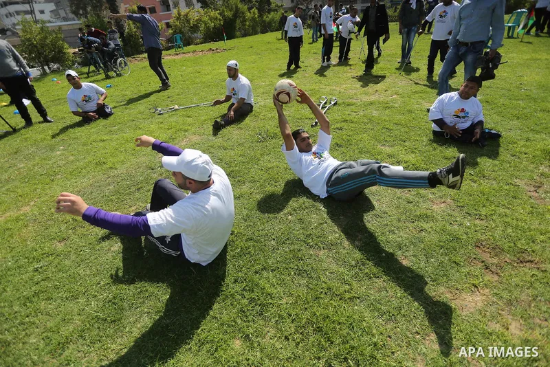 Disabled Palestinians play sitting volleyball during a local sports championship organized by Al Jazeera club in Gaza City April 7, 2016. Photo by Mohammed Asad