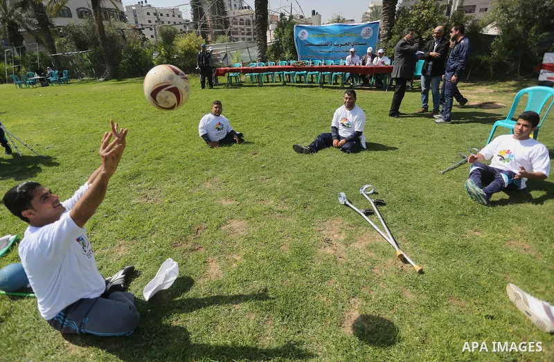 Disabled Palestinians play sitting volleyball during a local sports championship organized by Al Jazeera club in Gaza City April 7, 2016. Photo by Mohammed Asad