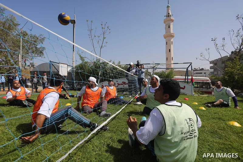 Disabled Palestinians play sitting volleyball during a local sports championship organized by Al Jazeera club in Gaza City April 7, 2016. Photo by Mohammed Asad