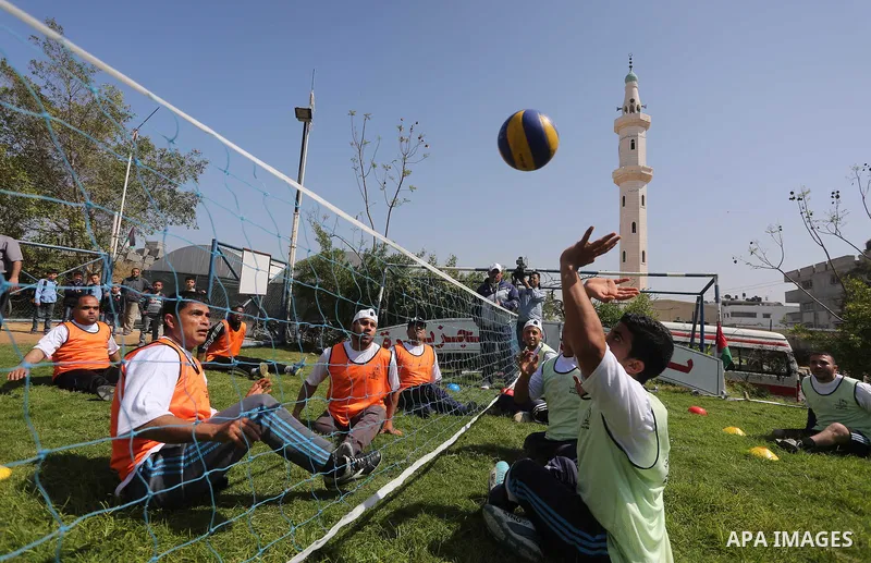 Disabled Palestinians play sitting volleyball during a local sports championship organized by Al Jazeera club in Gaza City April 7, 2016. Photo by Mohammed Asad