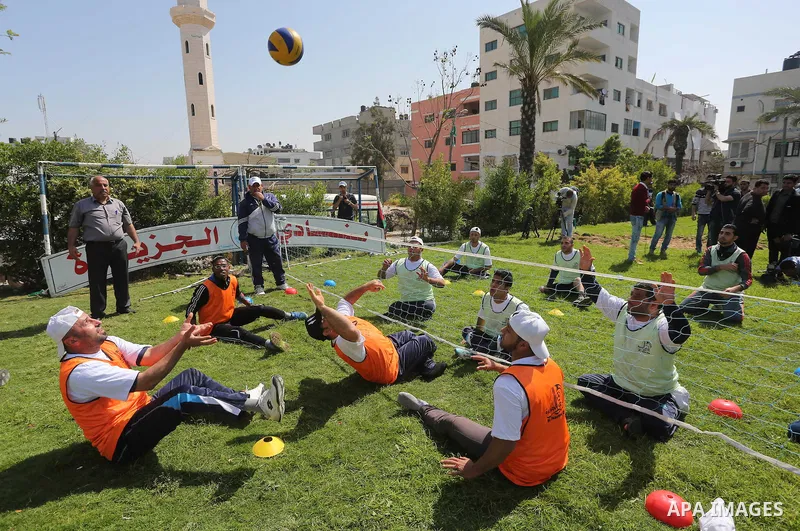 Disabled Palestinians play sitting volleyball during a local sports championship organized by Al Jazeera club in Gaza City April 7, 2016. Photo by Mohammed Asad