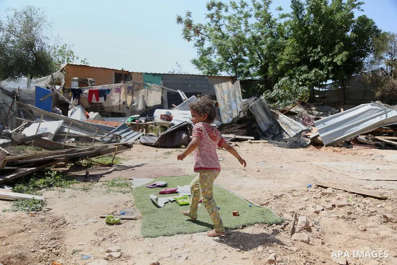 A girl from the Arab Jahalin Bedouin community walks past the debris of homes in the West Bank Bedouin camp of al-Khan al-Ahmar on April 7, 2016 after Israeli authorities demolished four houses that they said were built...