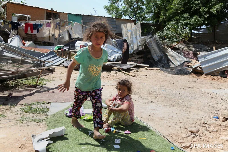 children from the Arab Jahalin Bedouin community play past the debris of homes in the West Bank Bedouin camp of al-Khan al-Ahmar on April 7, 2016 after Israeli authorities demolished four houses that they said were built...