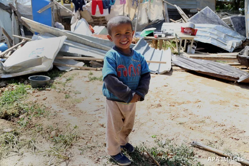 A child from the Arab Jahalin Bedouin community walks past the debris of homes in the West Bank Bedouin camp of al-Khan al-Ahmar on April 7, 2016 after Israeli authorities demolished four houses that they said were built...