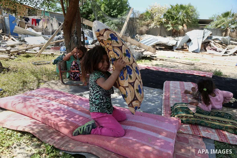 Children from the Arab Jahalin Bedouin community react to the demolition of their home in the West Bank Bedouin camp of al-Khan al-Ahmar on April 7, 2016 after Israeli authorities demolished four houses that they said we...