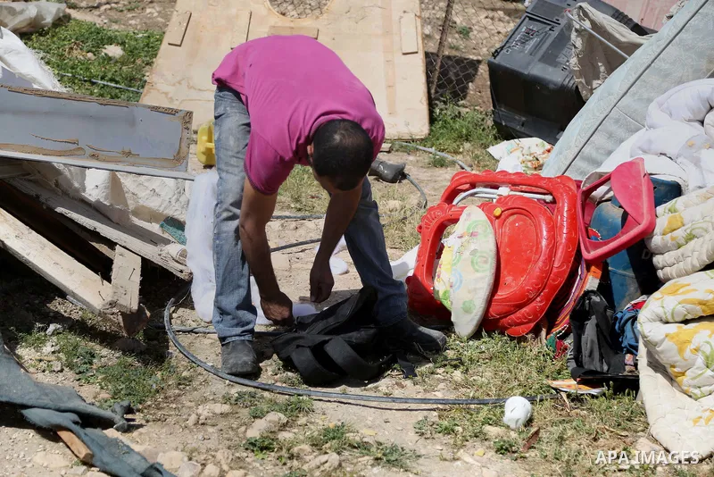 A man from the Arab Jahalin Bedouin community inspects debris of homes in the West Bank Bedouin camp of al-Khan al-Ahmar on April 7, 2016 after Israeli authorities demolished four houses that they said were built without...