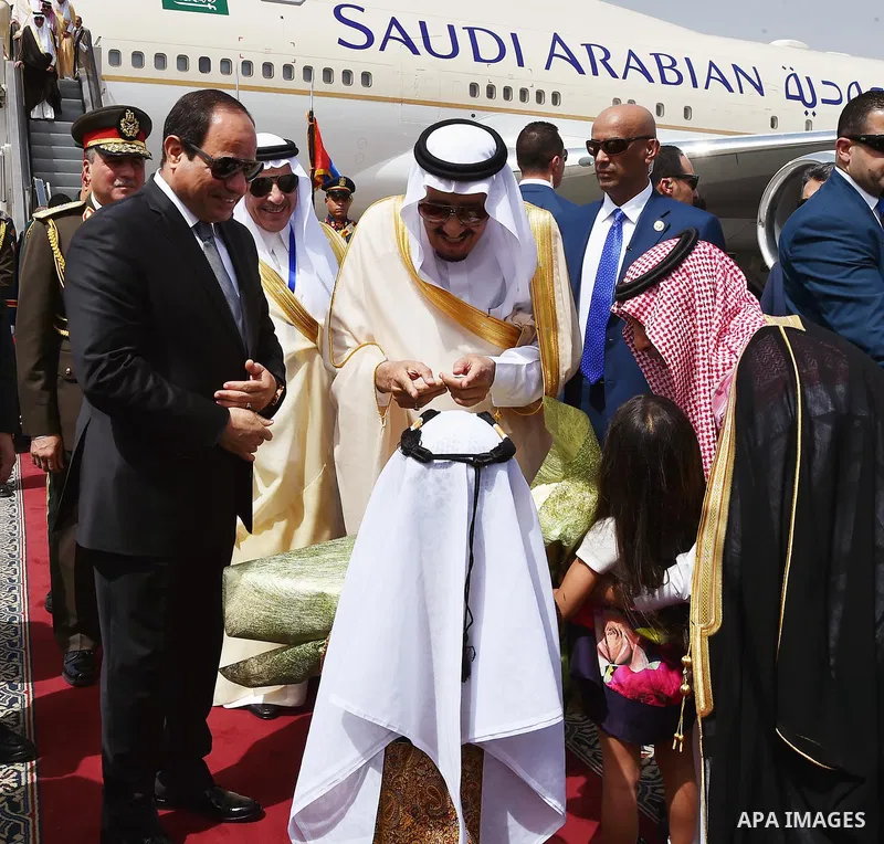 King Salman of Saudi Arabia greets a child with Egyptian President Abdel Fattah al-Sisi during the reception ceremony in Cairo airport in Cairo, Egypt April 7, 2016. Saudi King Salman started a five-day visit to Cairo in...