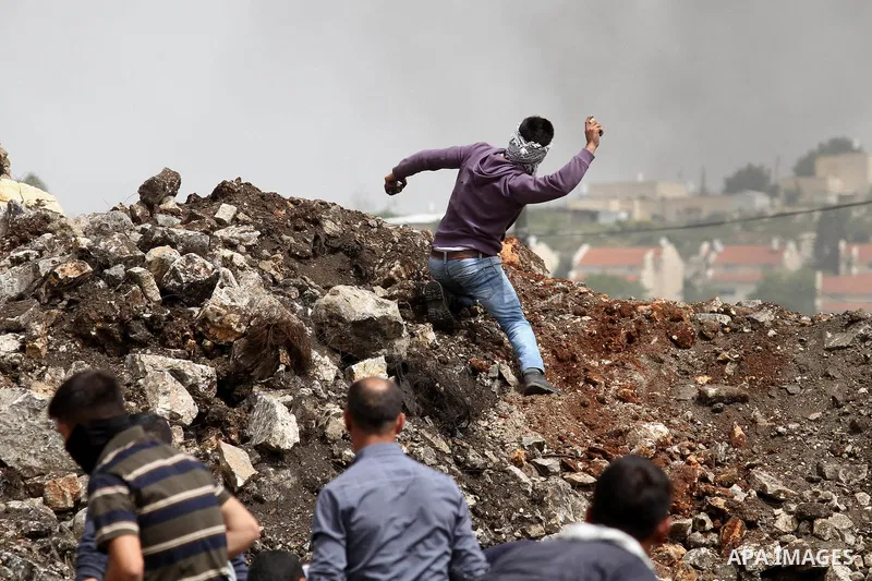 Palestinian protestesr hurl stones towards Israeli security forces during clashes following a weekly demonstration against the expropriation of Palestinian land by Israel in the village of Kfar Qaddum, near Nablus, in th...