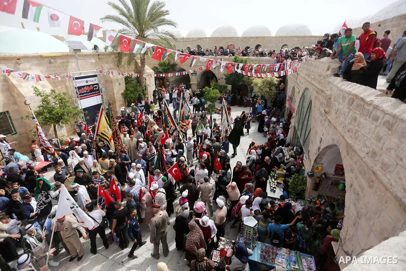 Palestinians attend a festival at the mosque of Nabi Musa, where the tomb of Prophet Moses is believed to be placed, in the Judean Desert neat the West Bank town of Jericho, on April 8, 2016. The festival sponsored by th...