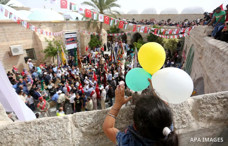 Palestinians attend a festival at the mosque of Nabi Musa, where the tomb of Prophet Moses is believed to be placed, in the Judean Desert neat the West Bank town of Jericho, on April 8, 2016. The festival sponsored by th...