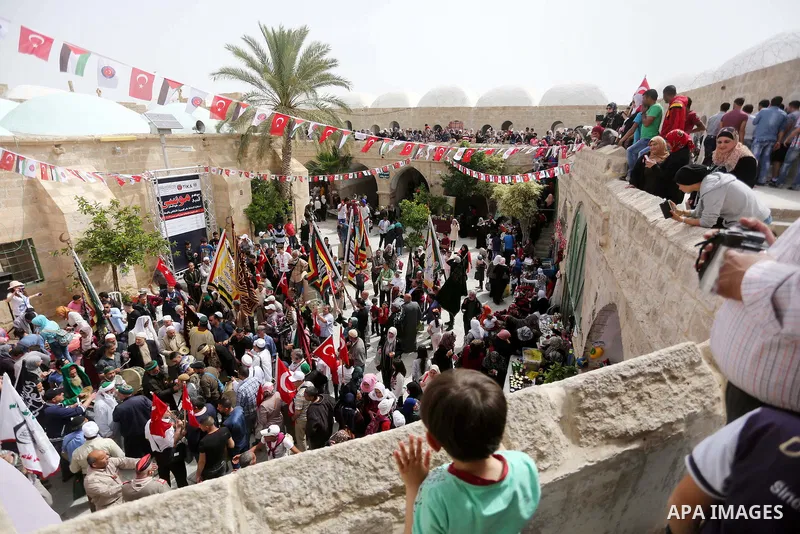 Palestinians attend a festival at the mosque of Nabi Musa, where the tomb of Prophet Moses is believed to be placed, in the Judean Desert neat the West Bank town of Jericho, on April 8, 2016. The festival sponsored by th...