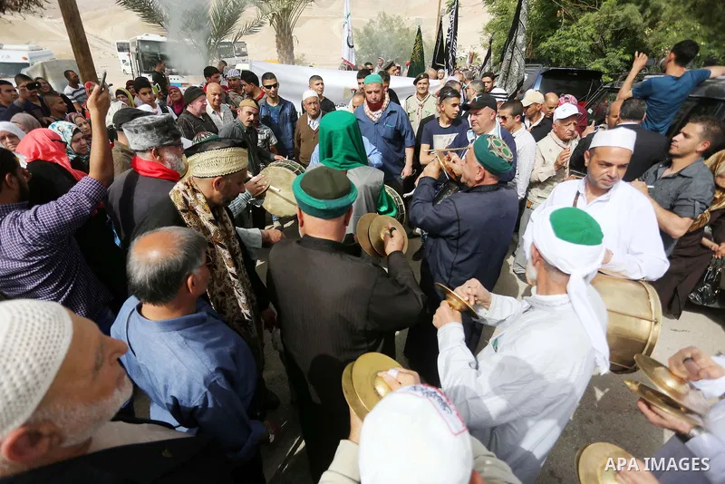 Palestinians perform during a festival at the mosque of Nabi Musa, where the tomb of Prophet Moses is believed to be placed, in the Judean Desert neat the West Bank town of Jericho, on April 8, 2016. The festival sponsor...
