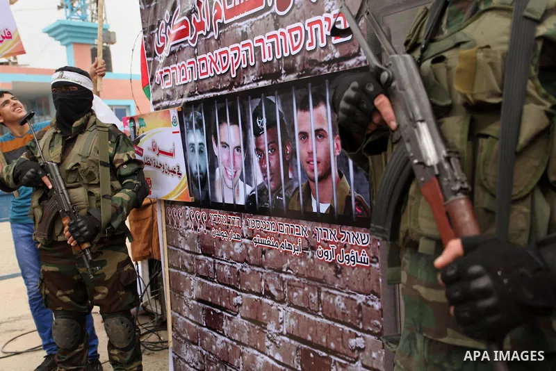 Members of the Ezzedine al-Qassam Brigades, the military wing of the Palestinian Islamist movement Hamas take part during a protest demanding release the prisoners in Israeli jails at the Erez crossing checkpoint in the...