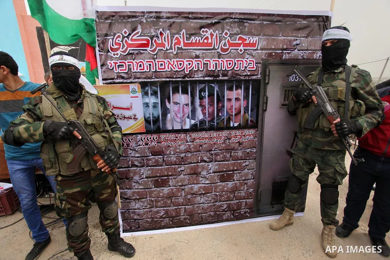 Members of the Ezzedine al-Qassam Brigades, the military wing of the Palestinian Islamist movement Hamas take part during a protest demanding release the prisoners in Israeli jails at the Erez crossing checkpoint in the...