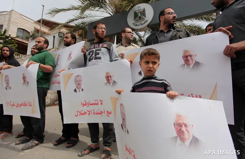 Palestinians hold banners during a protest against a power cut, in front of the Council of Ministers, in Gaza city, on April 11, 2016. Photo by Ashraf Amra