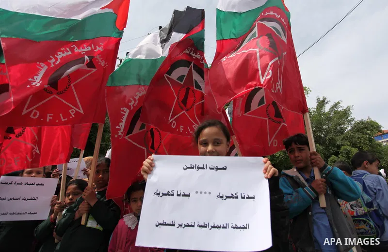 Palestinian supporters of the Democratic Front for the Liberation of Palestine (DFLP) shout slogans and hold banners during a protest against a power cut, in front of the Council of Ministers, in Gaza city, on April 11,...