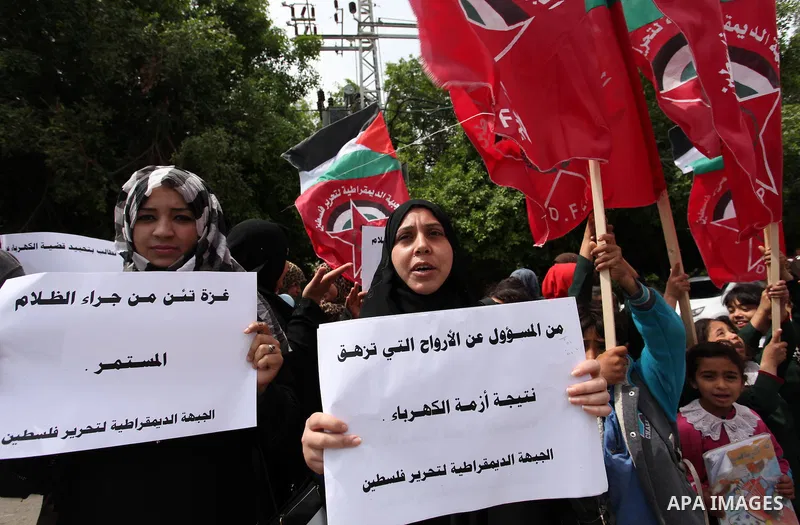 Palestinian supporters of the Democratic Front for the Liberation of Palestine (DFLP) shout slogans and hold banners during a protest against a power cut, in front of the Council of Ministers, in Gaza city, on April 11,...