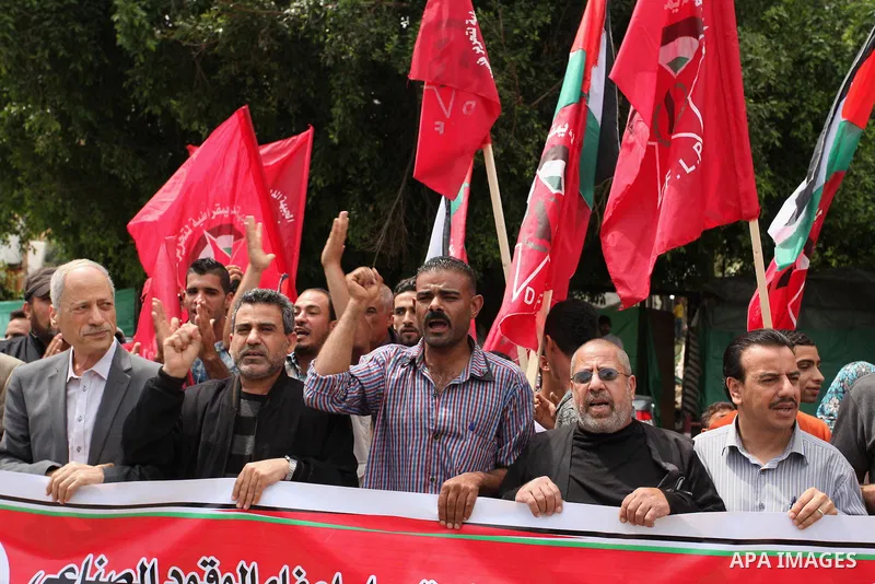 Palestinian supporters of the Democratic Front for the Liberation of Palestine (DFLP) shout slogans and hold banners during a protest against a power cut, in front of the Council of Ministers, in Gaza city, on April 11,...