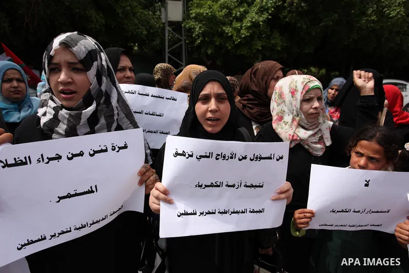 Palestinian supporters of the Democratic Front for the Liberation of Palestine (DFLP) shout slogans and hold banners during a protest against a power cut, in front of the Council of Ministers, in Gaza city, on April 11,...