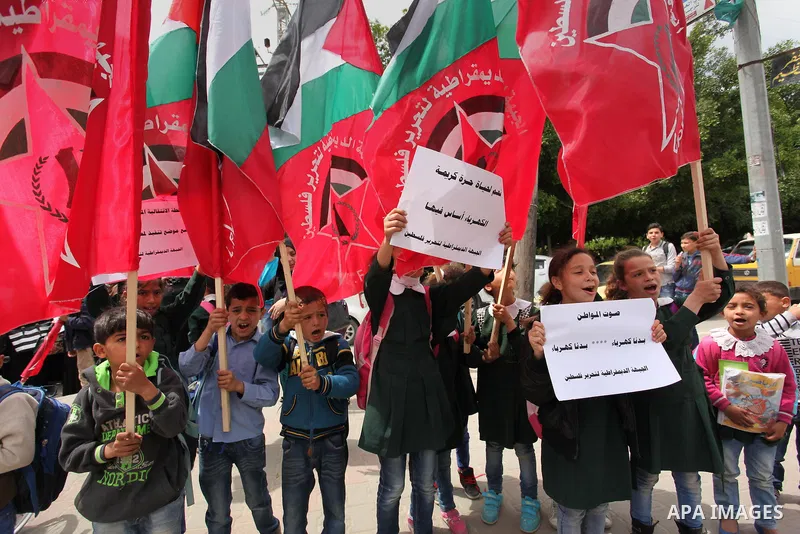 Palestinian supporters of the Democratic Front for the Liberation of Palestine (DFLP) shout slogans and hold banners during a protest against a power cut, in front of the Council of Ministers, in Gaza city, on April 11,...