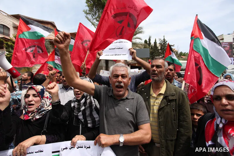 Palestinian supporters of the Democratic Front for the Liberation of Palestine (DFLP) shout slogans and hold banners during a protest against a power cut, in front of the Council of Ministers, in Gaza city, on April 11,...