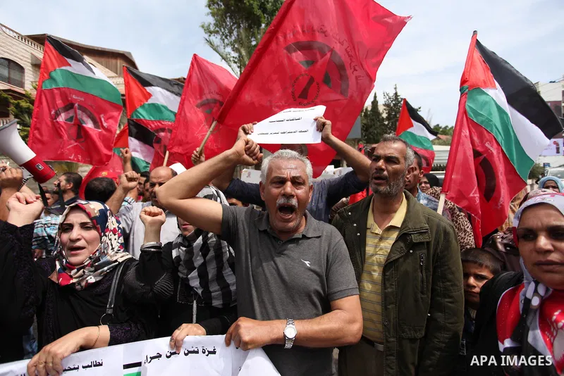 Palestinian supporters of the Democratic Front for the Liberation of Palestine (DFLP) shout slogans and hold banners during a protest against a power cut, in front of the Council of Ministers, in Gaza city, on April 11,...