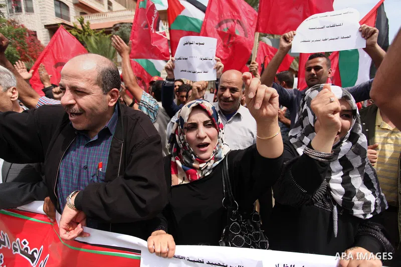 Palestinian supporters of the Democratic Front for the Liberation of Palestine (DFLP) shout slogans and hold banners during a protest against a power cut, in front of the Council of Ministers, in Gaza city, on April 11,...