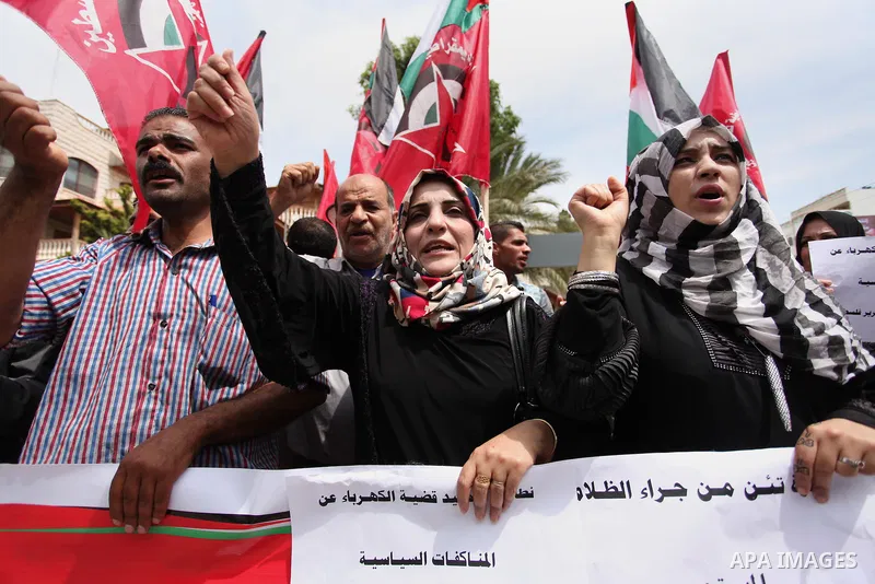 Palestinian supporters of the Democratic Front for the Liberation of Palestine (DFLP) shout slogans and hold banners during a protest against a power cut, in front of the Council of Ministers, in Gaza city, on April 11,...