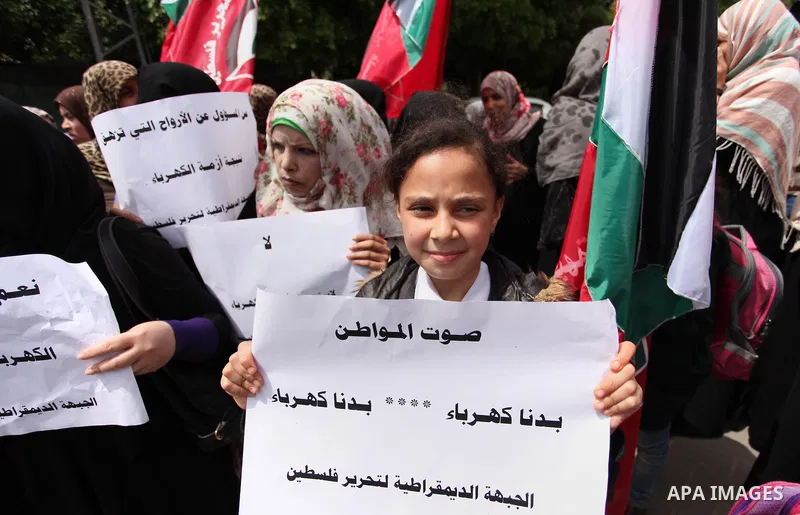 Palestinian supporters of the Democratic Front for the Liberation of Palestine (DFLP) shout slogans and hold banners during a protest against a power cut, in front of the Council of Ministers, in Gaza city, on April 11,...