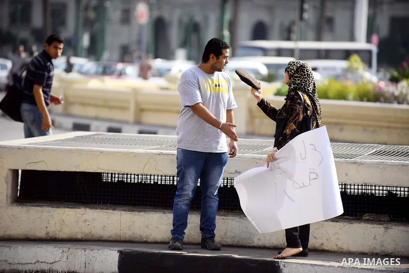 An Egyptian woman argue with an Egyptian protester as he holds placard wrote in arabic "Awwad sold his land" at Tahrir square in Cairo on April 11, 2016. Egypt and Saudi Arabia agreed to maritime borders that handed owne...