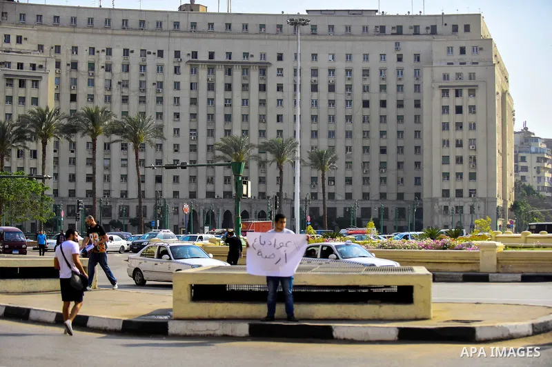 An Egyptian protester holds placard wrote in arabic "Awwad sold his land" at Tahrir square in Cairo on April 11, 2016. Egypt and Saudi Arabia agreed to maritime borders that handed ownership of disputed Red Sea islands T...