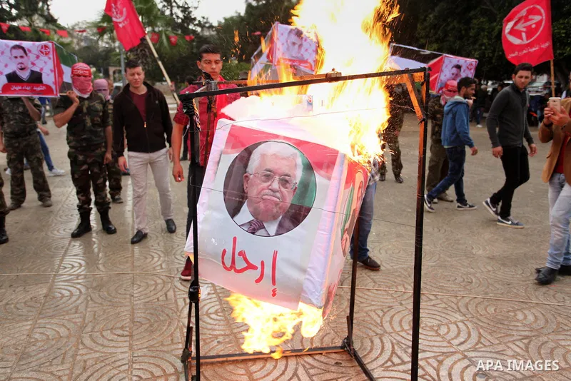 Supporters of the Popular Front for the Liberation of Palestine (PFLP) burn a poster of Palestinian President Mahmoud Abbas during a protest against Abbas's policies, in Gaza City April 12, 2016. The poster reads, "Leave...
