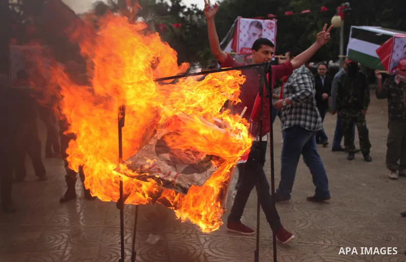 Supporters of the Popular Front for the Liberation of Palestine (PFLP) burn a poster of Palestinian President Mahmoud Abbas during a protest against Abbas's policies, in Gaza City April 12, 2016. The poster reads, "Leave...