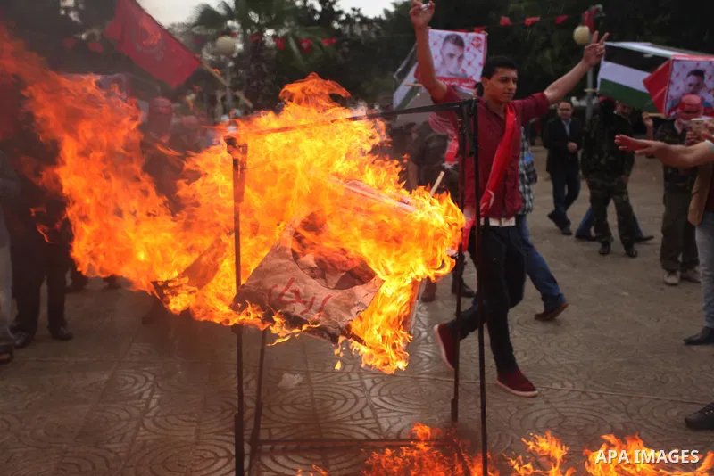 Supporters of the Popular Front for the Liberation of Palestine (PFLP) burn a poster of Palestinian President Mahmoud Abbas during a protest against Abbas's policies, in Gaza City April 12, 2016. The poster reads, "Leave...