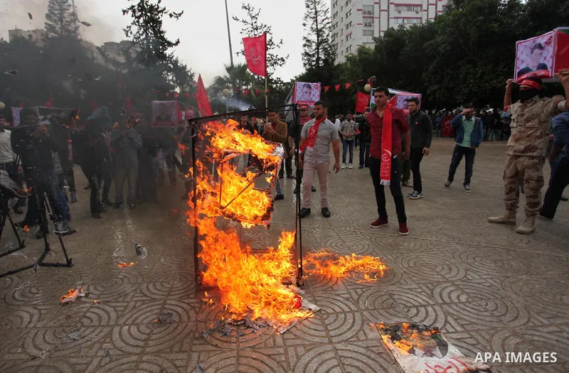 Supporters of the Popular Front for the Liberation of Palestine (PFLP) burn a poster of Palestinian President Mahmoud Abbas during a protest against Abbas's policies, in Gaza City April 12, 2016. The poster reads, "Leave...