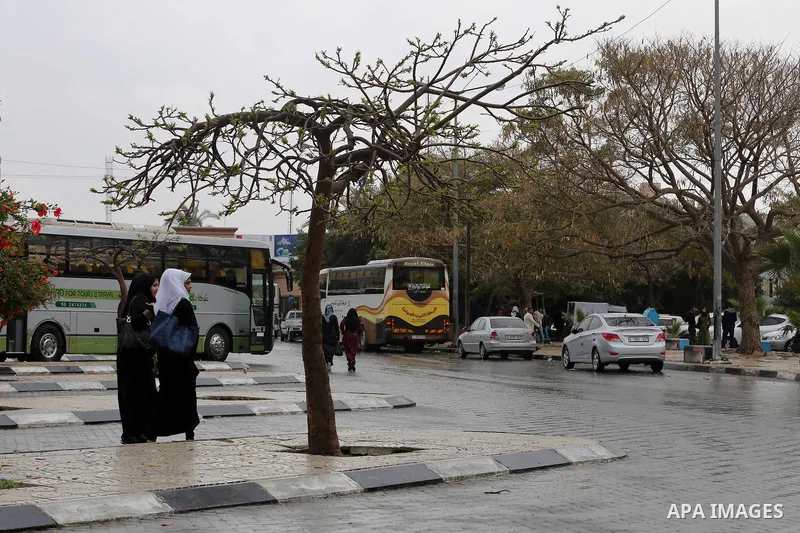 Palestinians walk in a flooded street during a rainy day, in Gaza City on April 12, 2016. Photo by Mohammed Asad