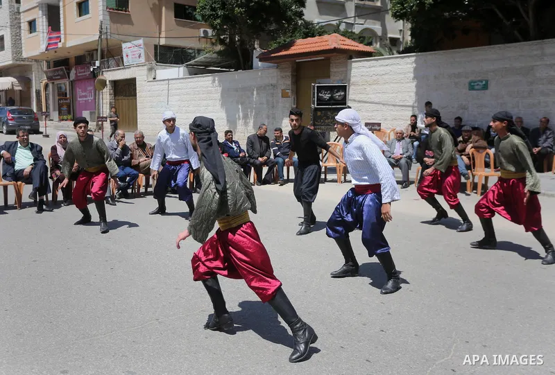 Palestinians youth participate in dancing of "Dabka" during a protest marking Palestinian Prisoners' Day in front of Red cross office in Gaza City April 14, 2016. Photo by Mohammed Asad