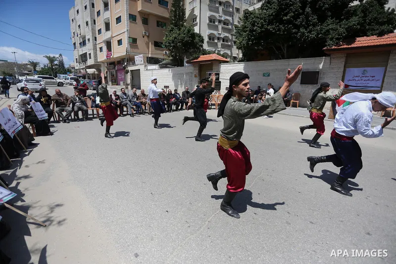 Palestinians youth participate in dancing of "Dabka" during a protest marking Palestinian Prisoners' Day in front of Red cross office in Gaza City April 14, 2016. Photo by Mohammed Asad